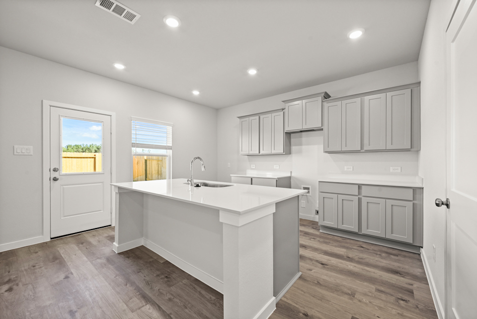 A kitchen with white cabinets.