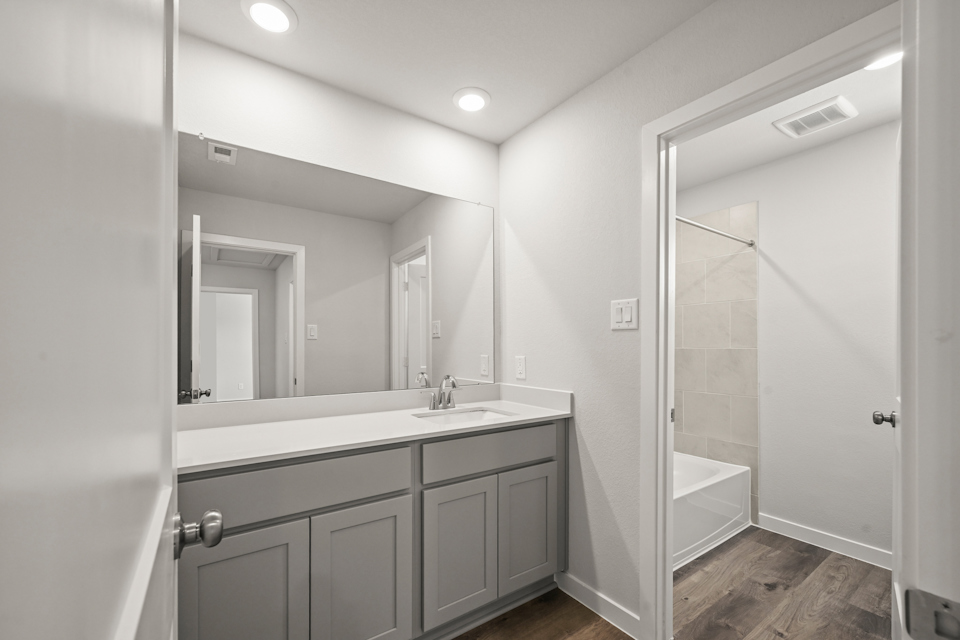 A bathroom with a sink and a shower unit.