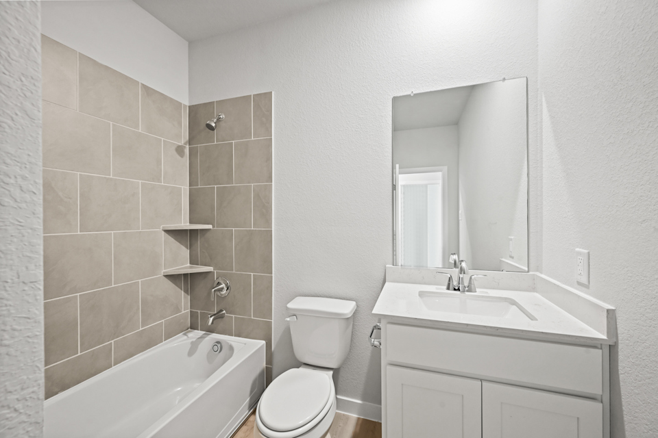 A bathroom with a tub sink and toilet.