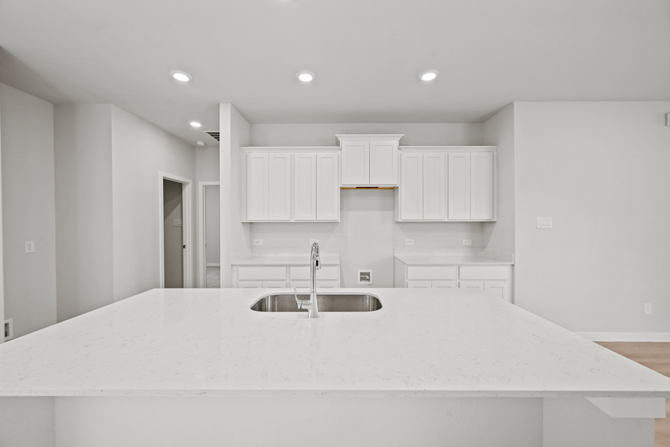 A kitchen with white cabinets.