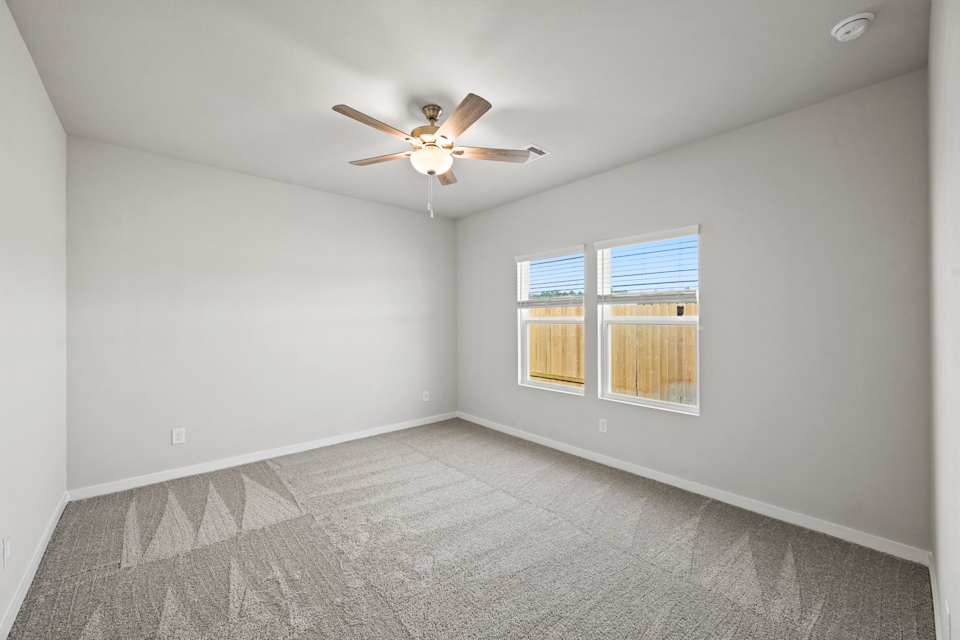 A room with a ceiling fan and a window.
