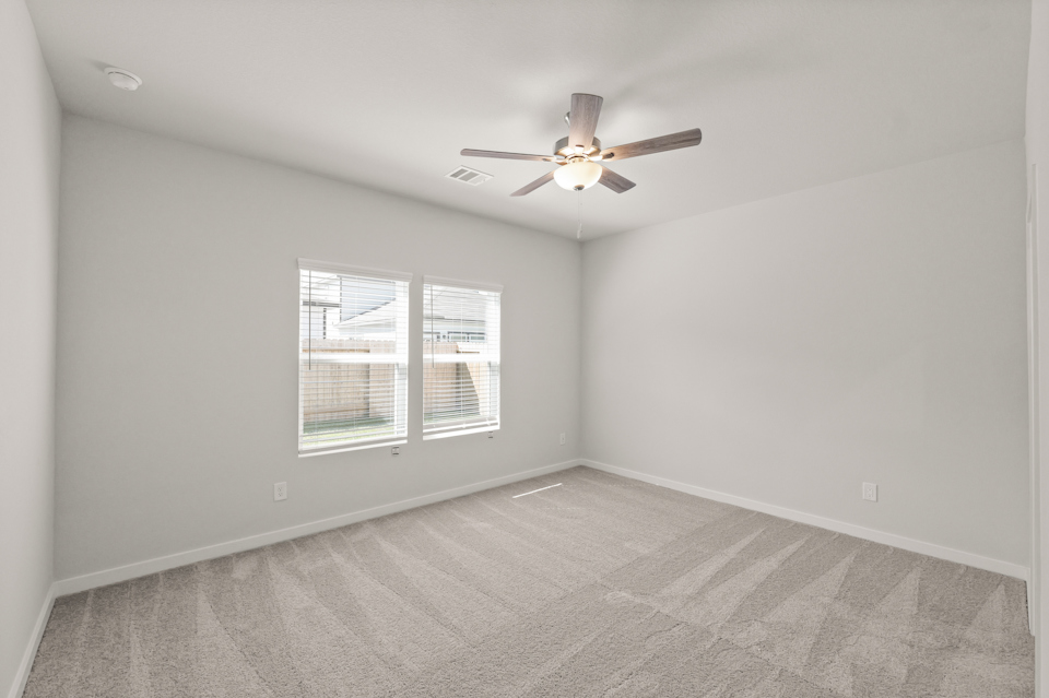 A room with a ceiling fan and a window.