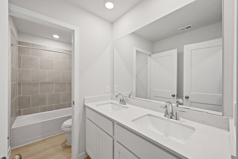 A bathroom with a tub sink and toilet.