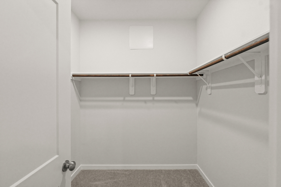 A white wall with a metal bar.