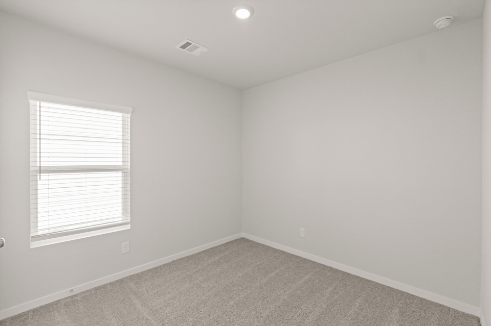 A room with a window and a carpet.