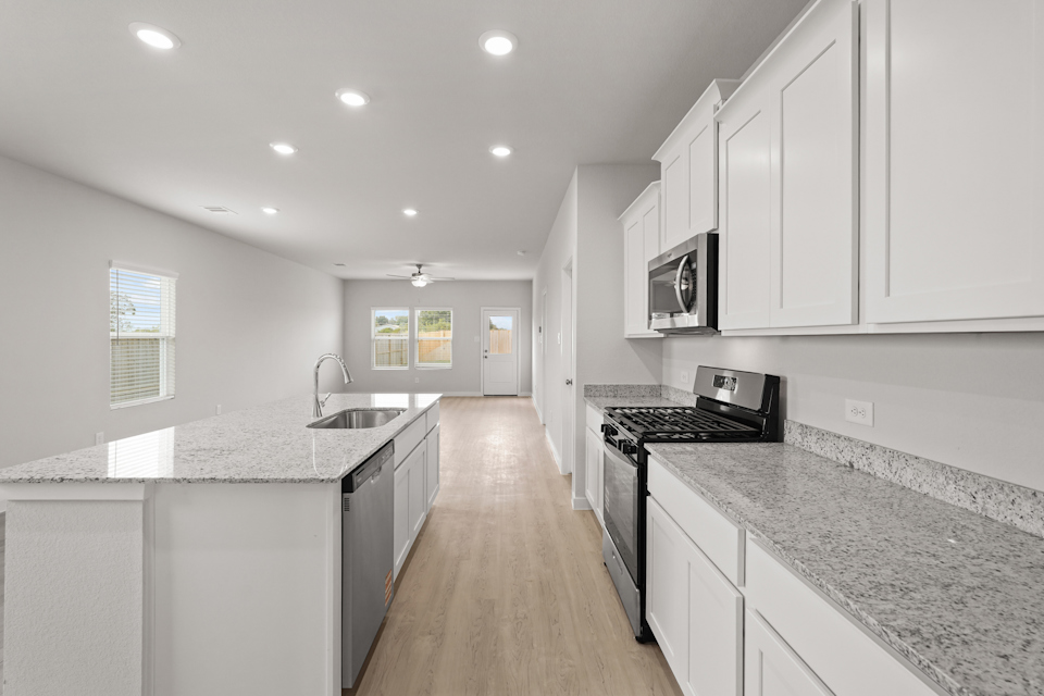 A kitchen with white cabinets.