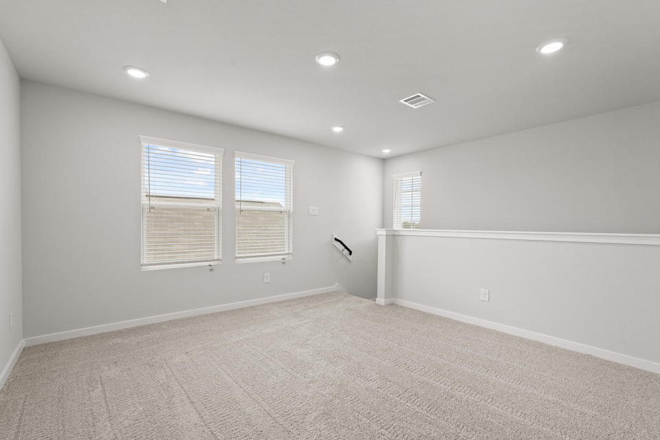 A room with a carpet and windows.