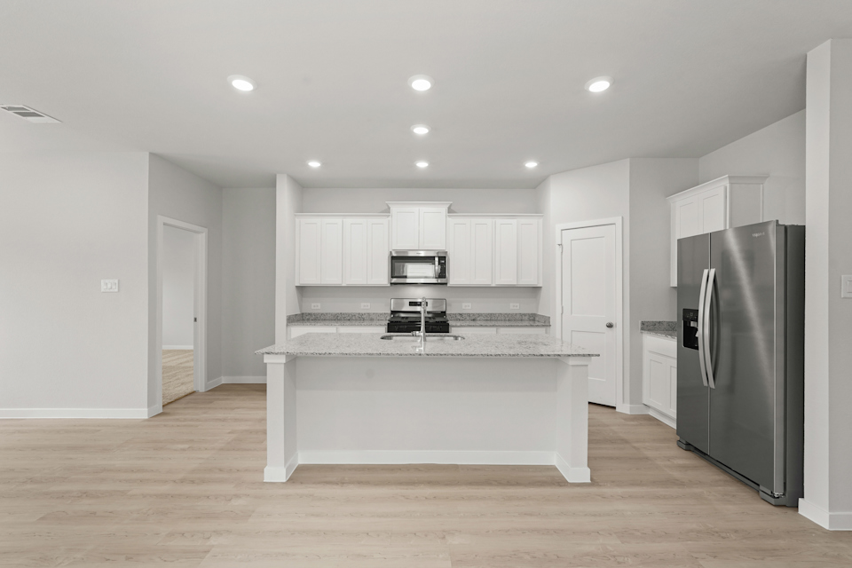 A kitchen with white cabinets.