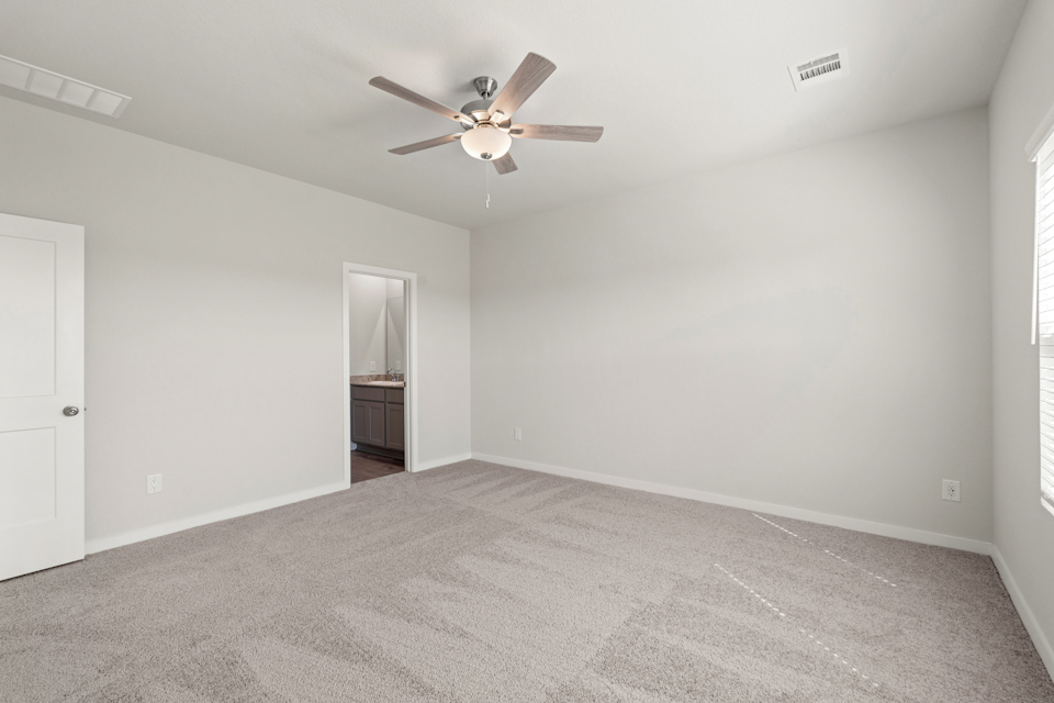 A room with a ceiling fan and a door.