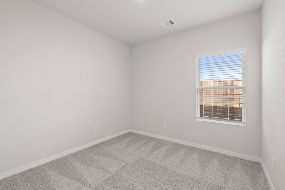 A room with a window and a carpet.