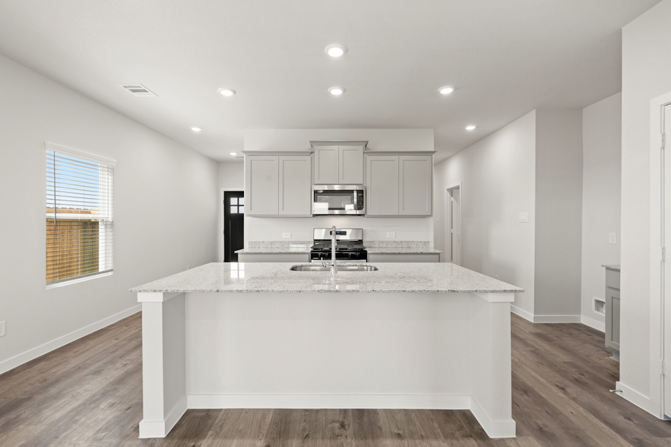 A kitchen with a marble counter top.