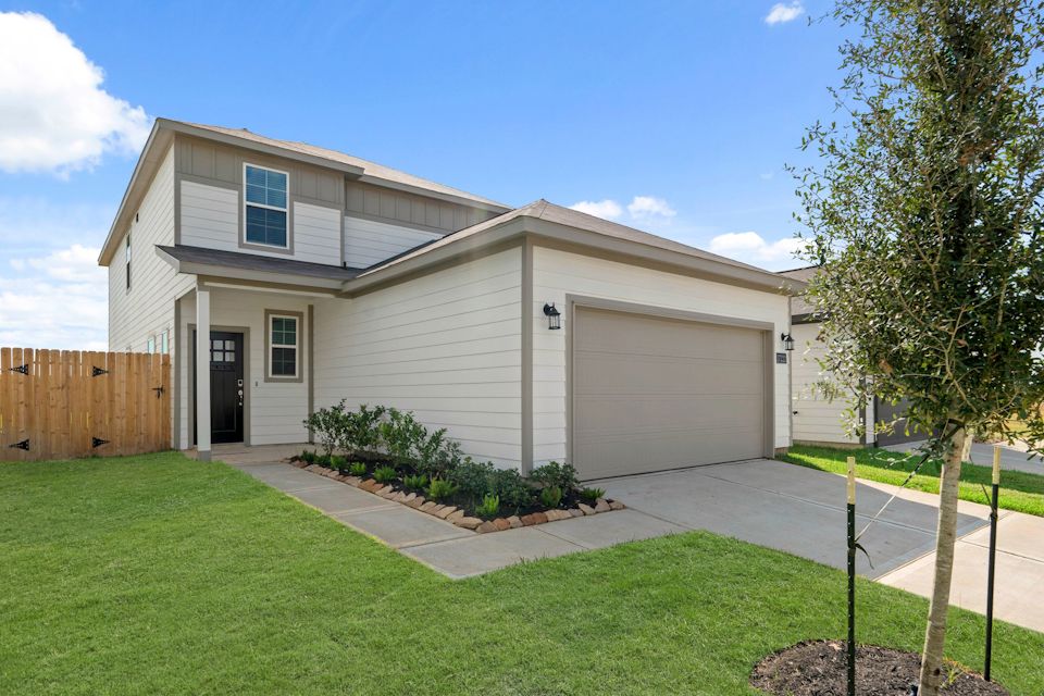 A house with a tree in the front yard.