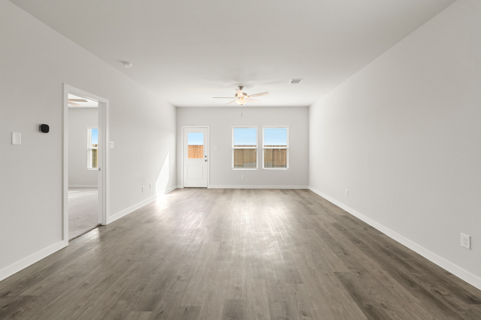 A room with a wood floor and a ceiling fan.