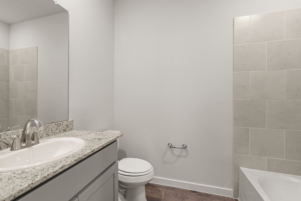 A bathroom with a sink toilet and bathtub.