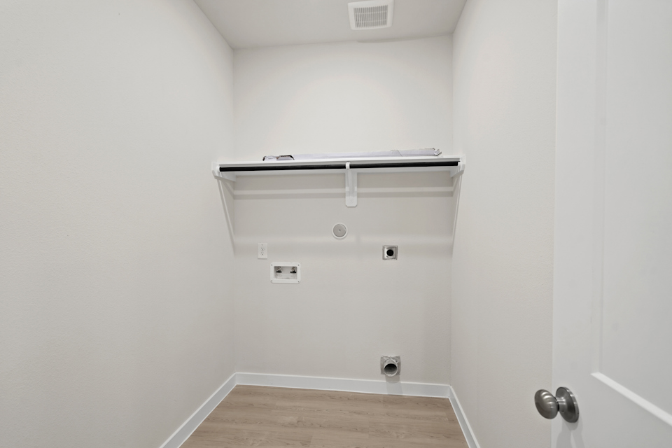 A white wall with a metal bar.