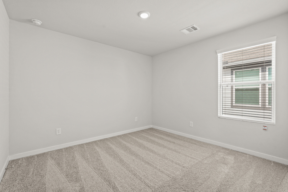 A room with a window and a carpet.