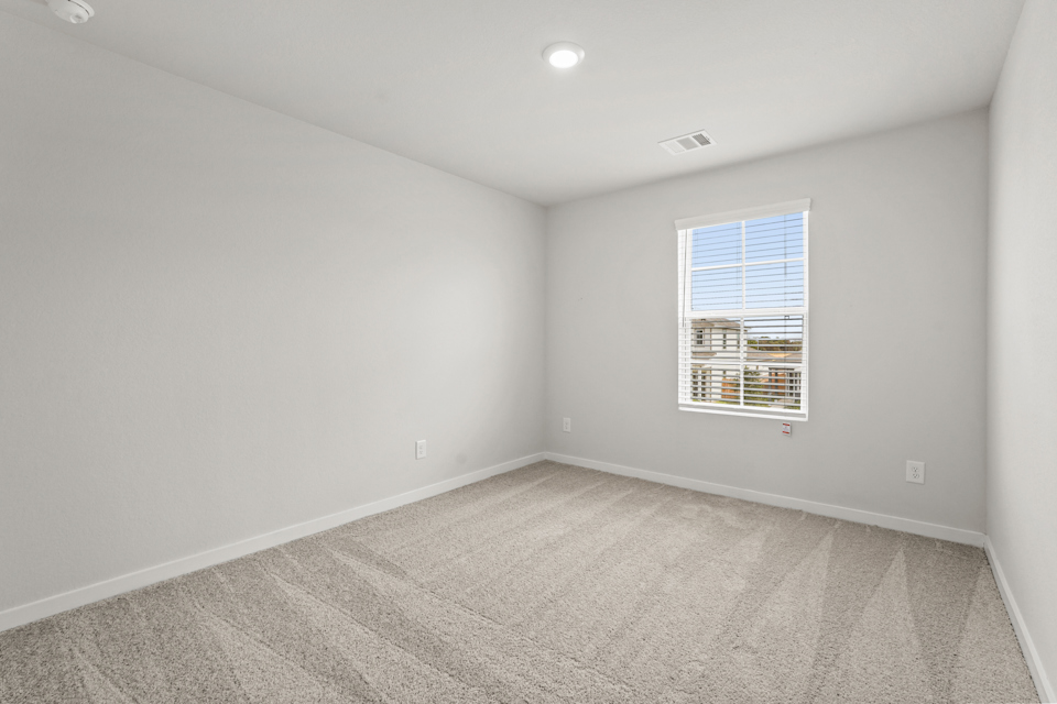 A room with a window and a carpet.