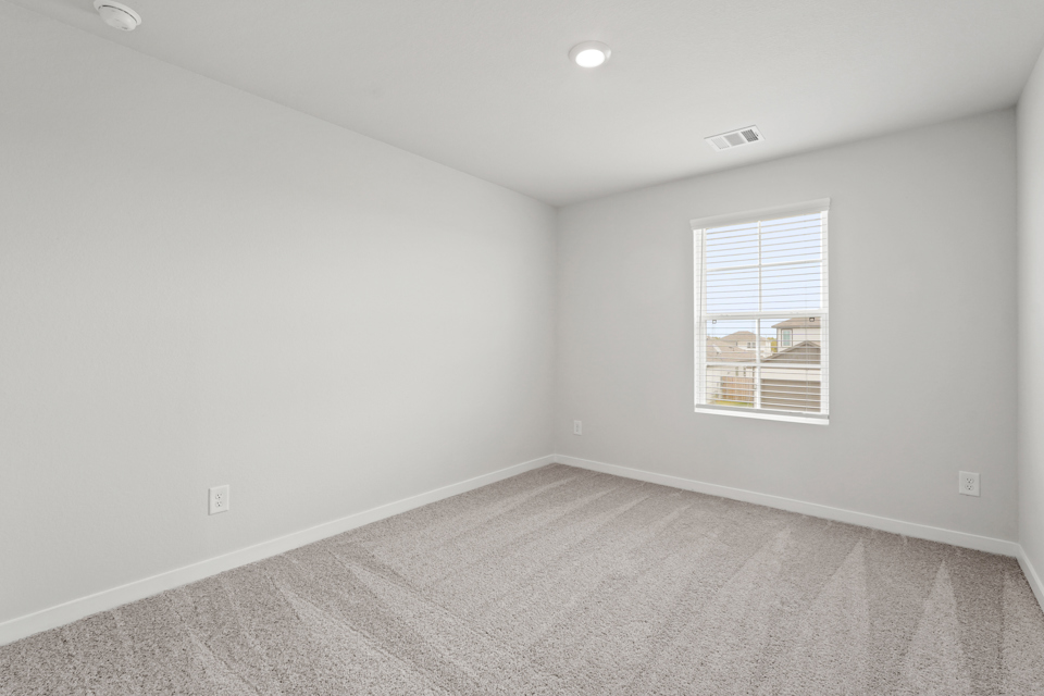 A room with a window and a carpet.