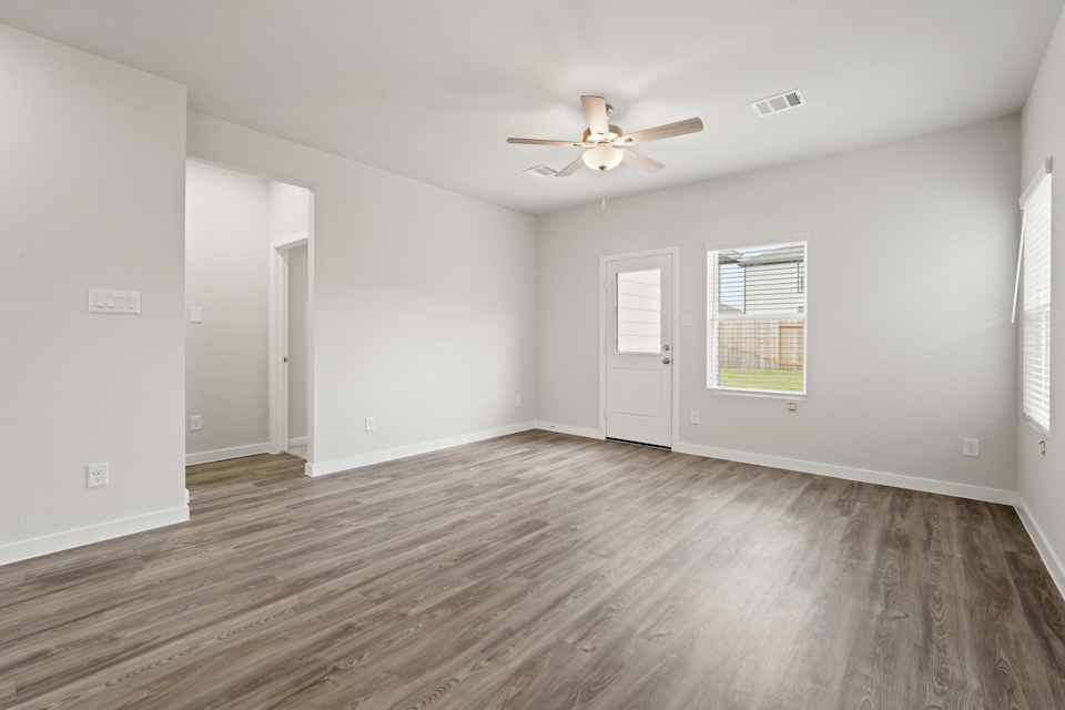 A room with a wood floor and a ceiling fan.