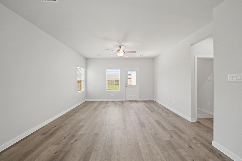 A room with a wood floor and a ceiling fan.