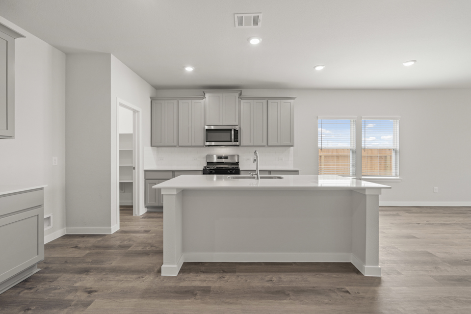 A kitchen with white cabinets.