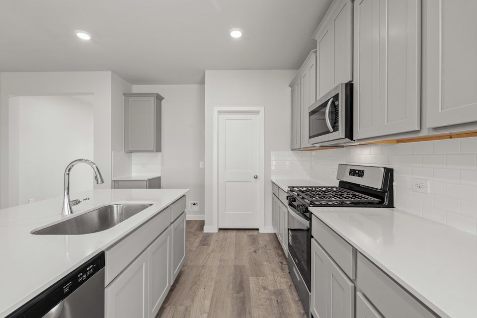 A kitchen with white cabinets.