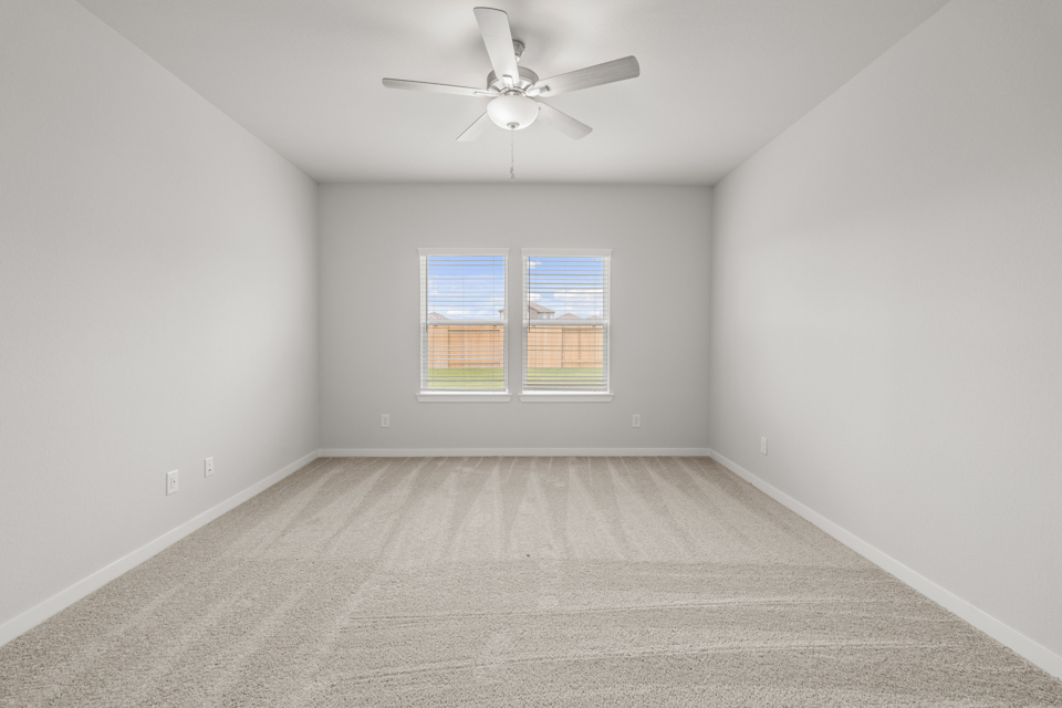 A room with a ceiling fan and a window.