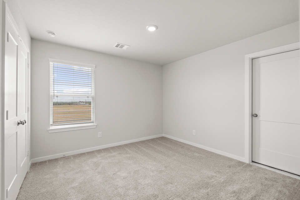 A room with a carpet and a window.