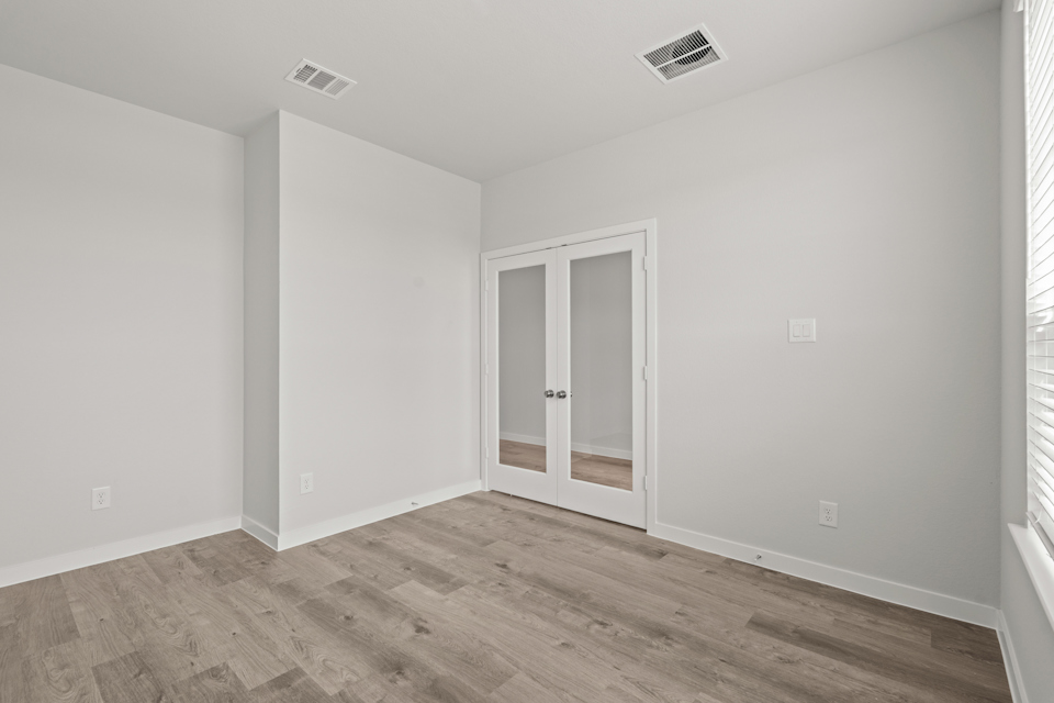A room with a wood floor and a door.