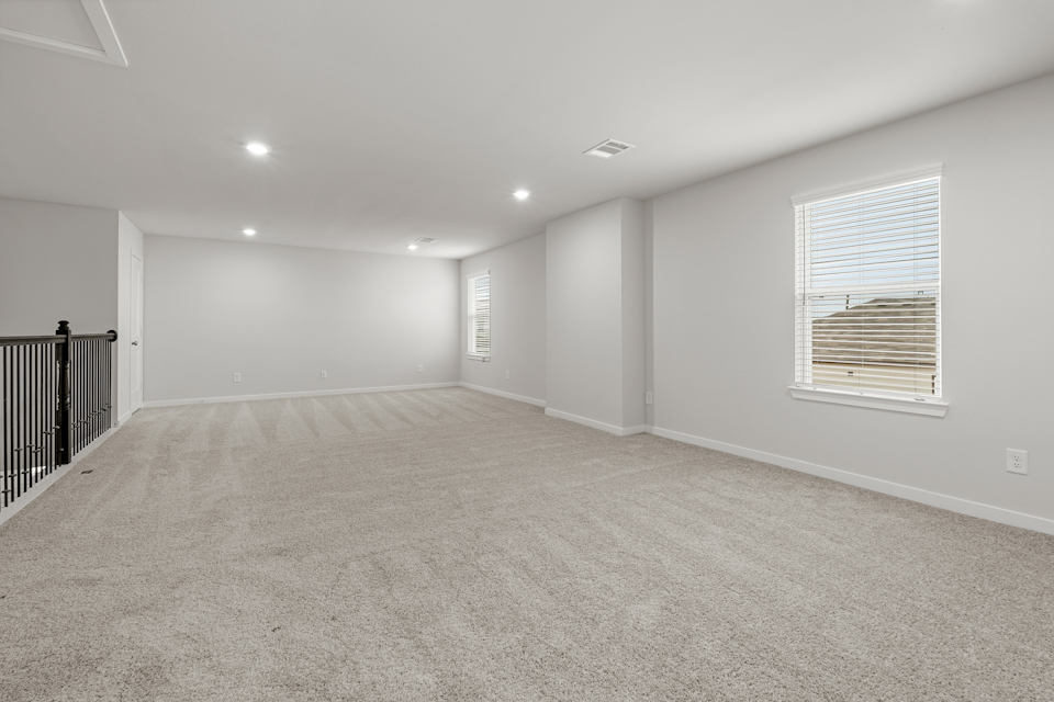 A room with a carpet and a window.