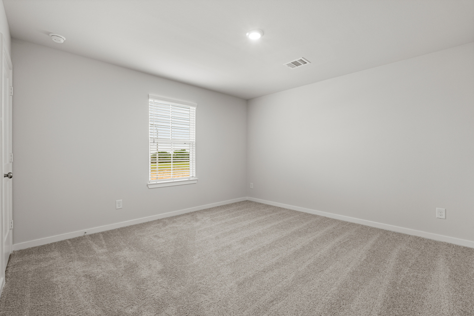 A room with a window and carpet.