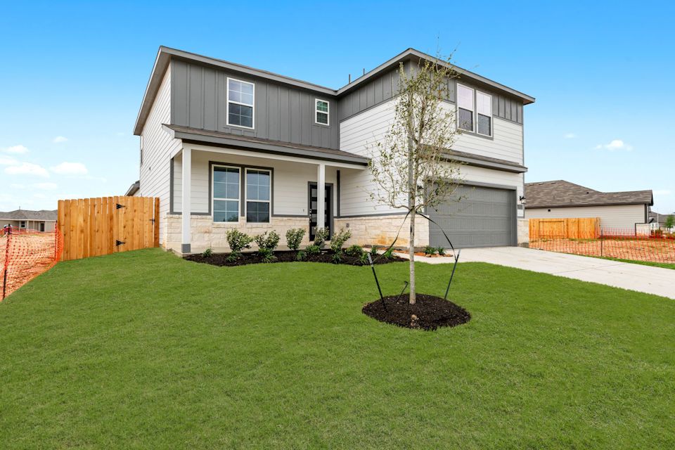 A house with a tree in the front yard.