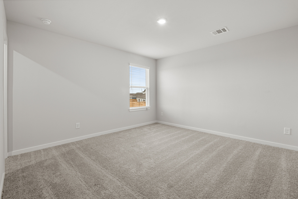 A room with a carpet and a window.