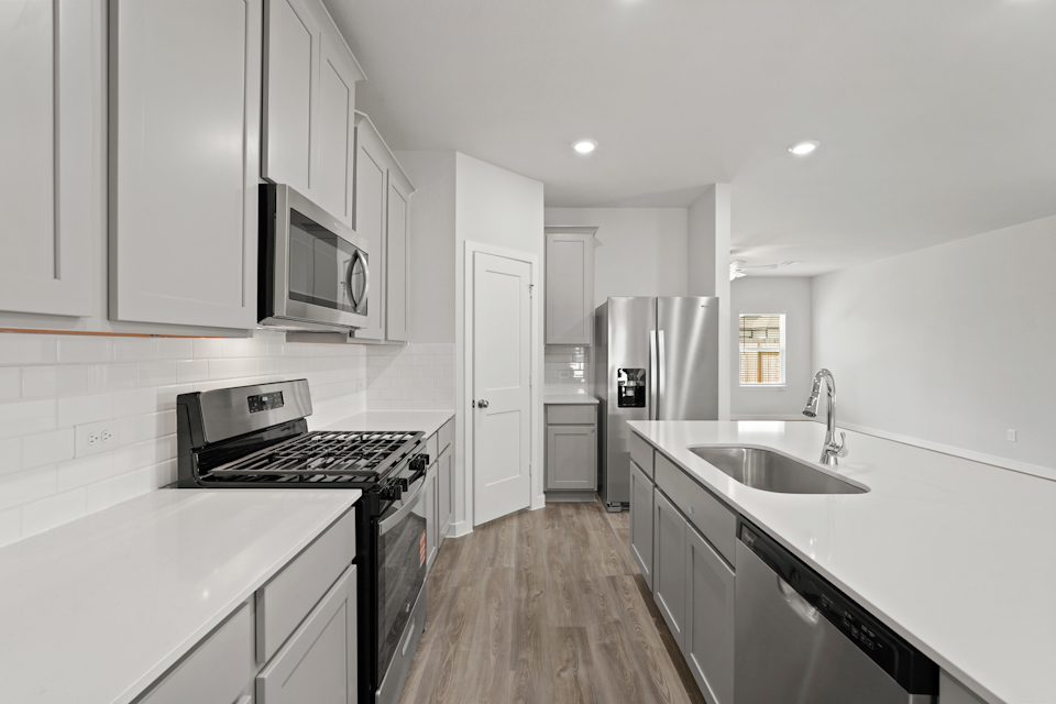 A kitchen with white cabinets.