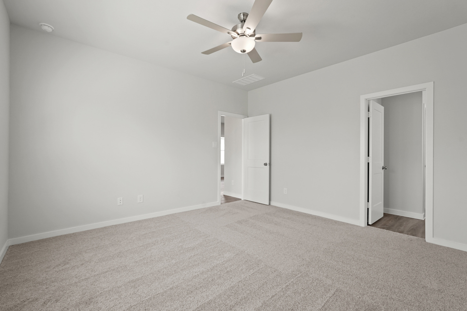 A room with a ceiling fan and a door.