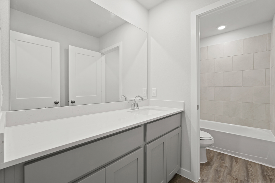 A bathroom with a tub sink and toilet.