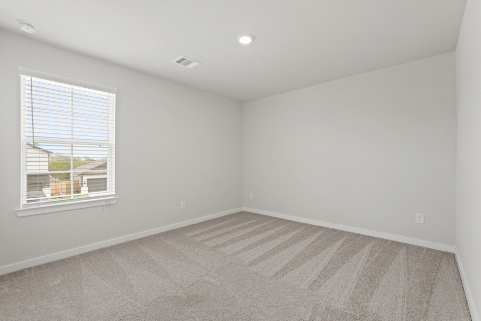 A room with a window and a carpet.