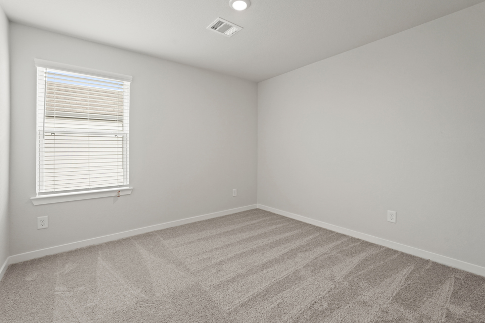 A room with a carpet and a window.