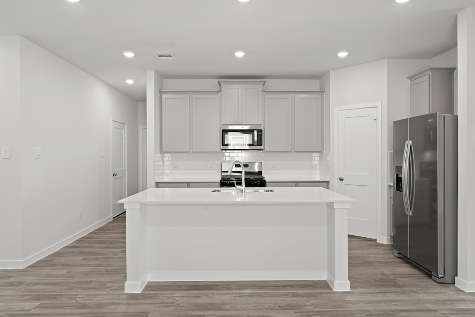 A kitchen with white cabinets.