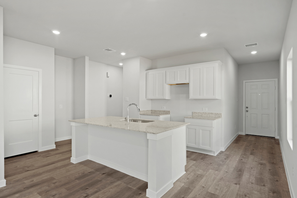 A kitchen with white cabinets.