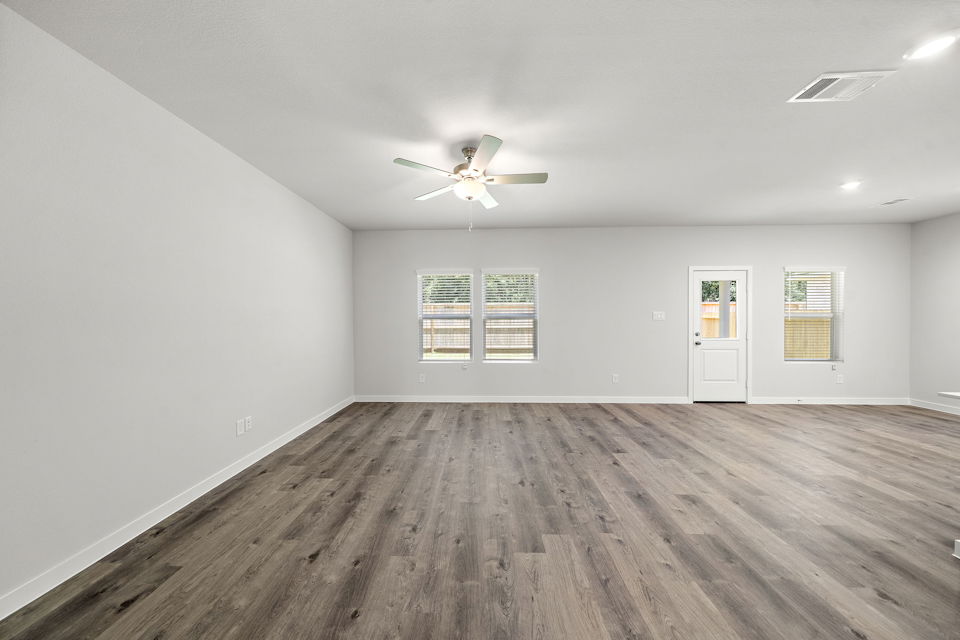 A room with a wood floor and a ceiling fan.