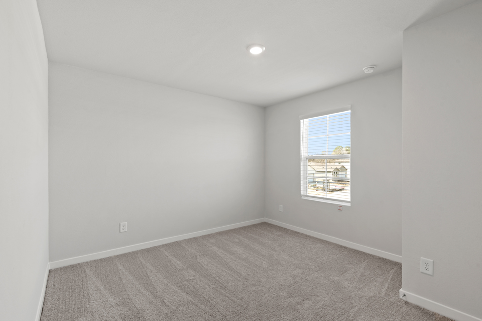 A room with a window and carpet.