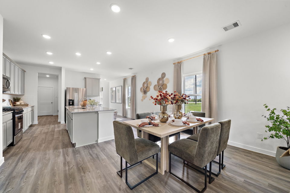 A dining room with a table and chairs.