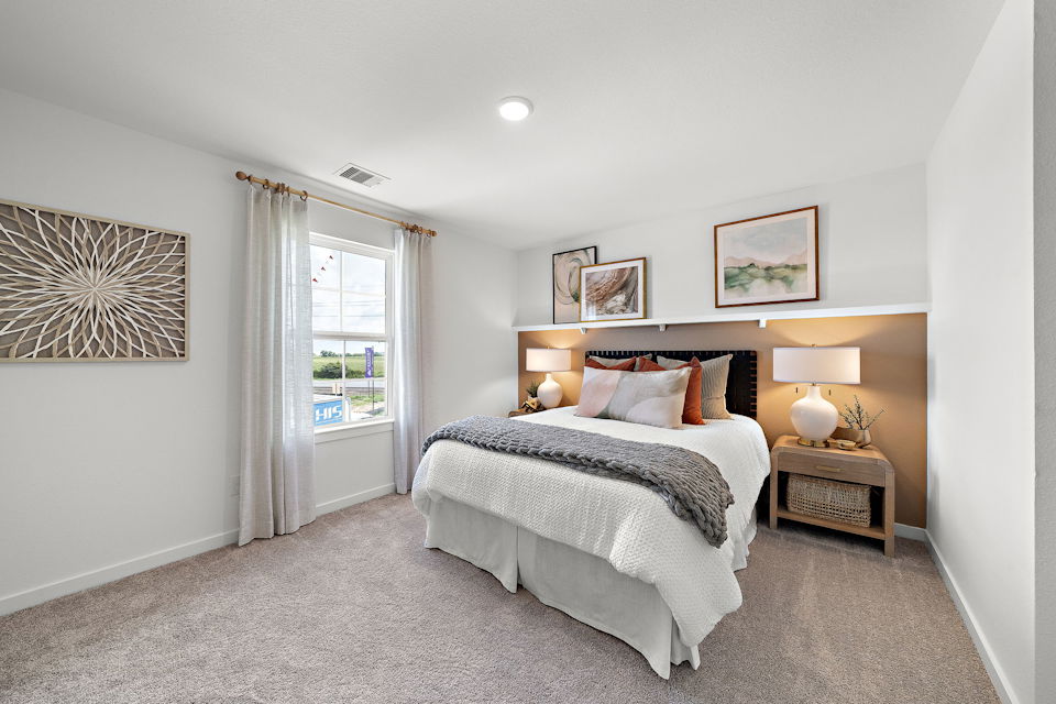 A bedroom with a bed and lamps.