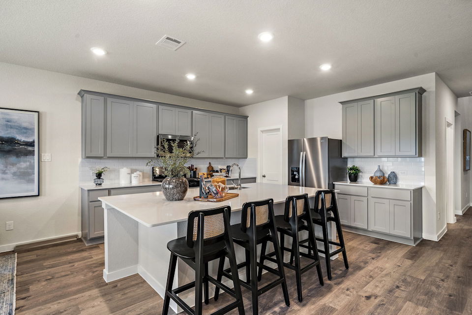 A kitchen with a dining table and chairs.