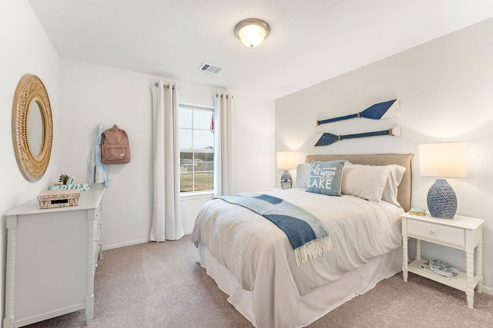 A bedroom with a bed and a mirror.