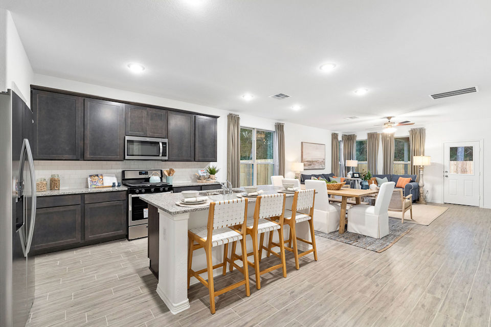 A kitchen with a dining table and chairs.