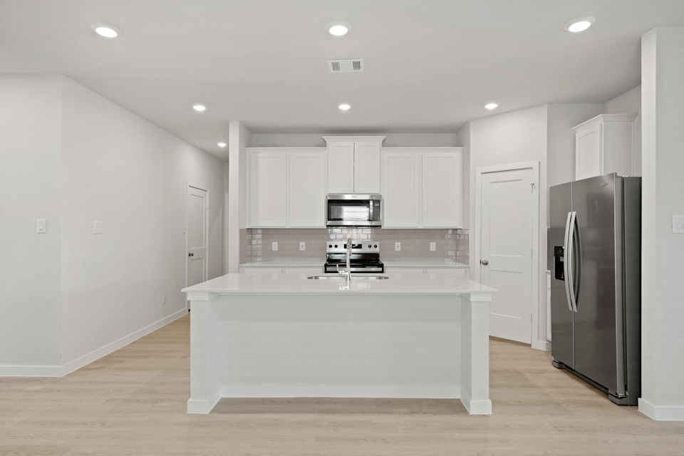 A kitchen with white cabinets.