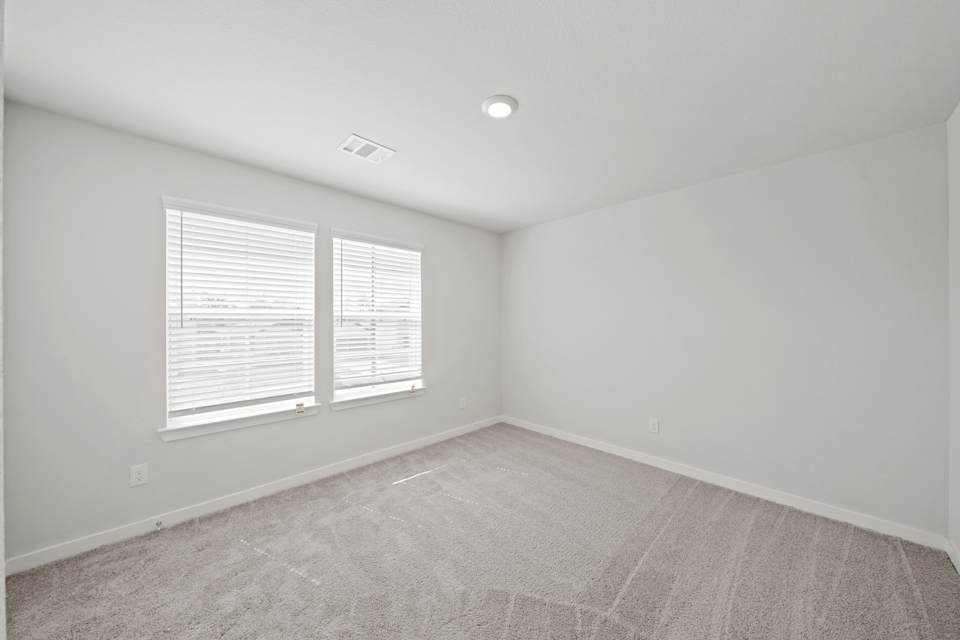 A room with a window and a carpet.