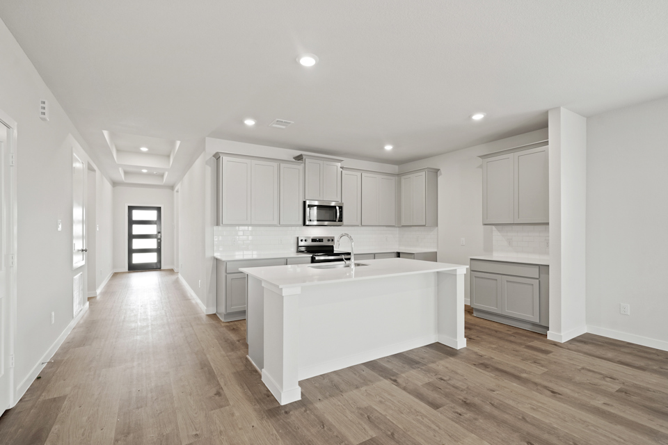 A kitchen with white cabinets.